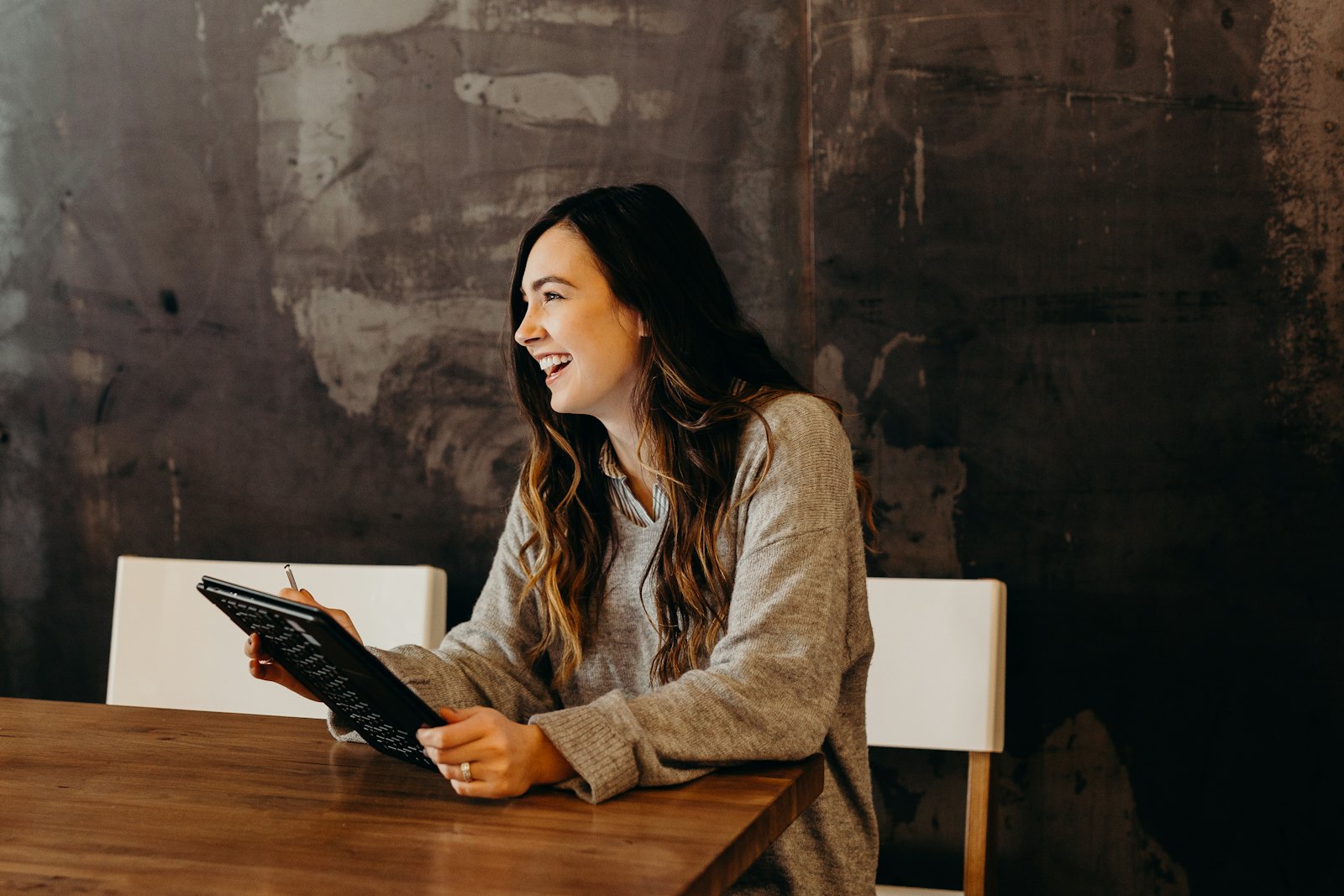 A creator laughing while reading on a tablet